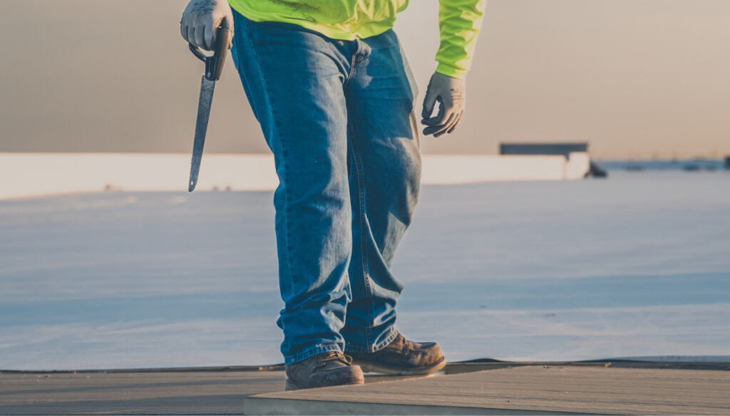 King of Texas roofer stepping across roof panels during inspection and maintenance.