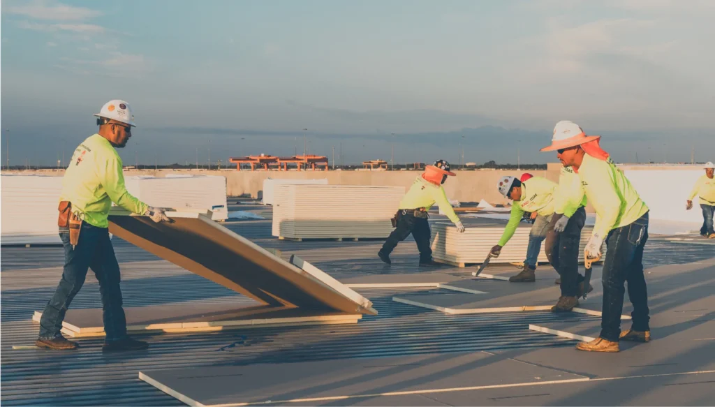 King of Texas commercial roofing contractor installing roof panels on an active job site