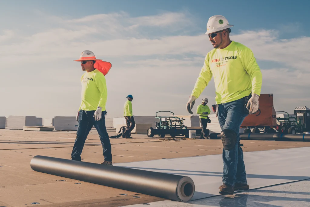 King of Texas commercial roofing contractor installing roofing membrane on a large facility