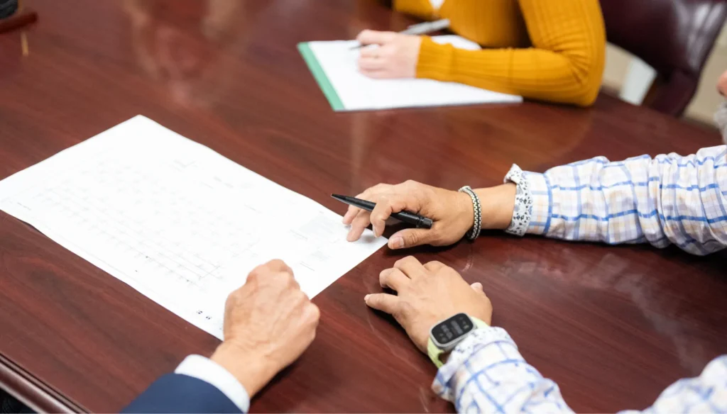 King of Texas project leaders reviewing roofing plans and documentation during a pre-construction meeting, ensuring scope alignment, accuracy, and a smooth execution before work begins.